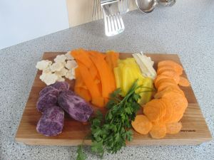 Das zu frittierende Gemüse im Uhrzeigersinn: vorne links die violetten Erdäpfeln, dann der Sellerie, rote Karotten, gelbe Karotten, Petersilienwurzel, Süßkartoffel und Petersilie.