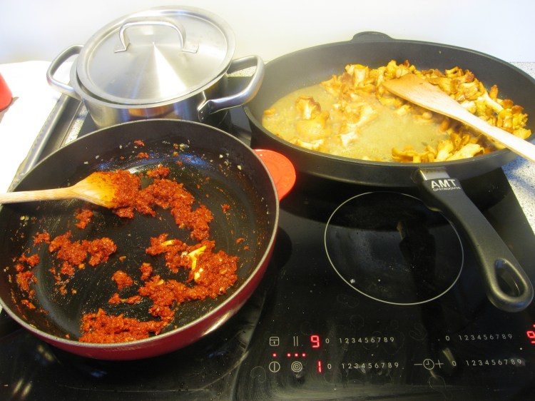 links hinten die Knödel im kochenden Salzwasser, rechts die Eierschwammerl müssen noch Wasser verlieren bis sie rösten, vorne die Gulyaschwürze auf Warteposition.