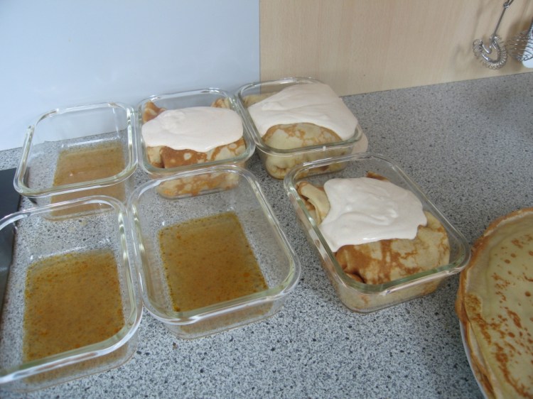 Beim Portionieren die Behälter mit etwas Saft auspolstern und dann die Hortobágyi-Palatschinken darin auslegen. 