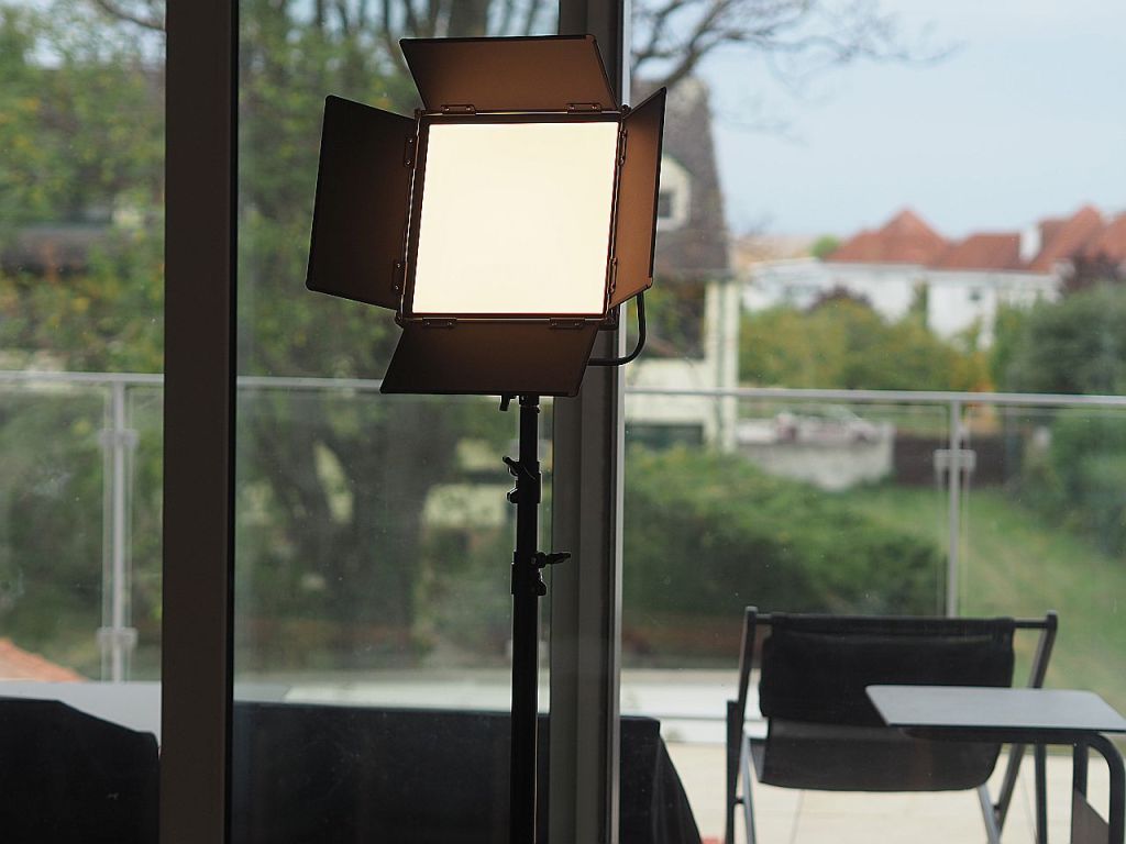 Ein professionelles Lichtgerät steht vor einer Fensterfront und beleuchtet den Raum.
