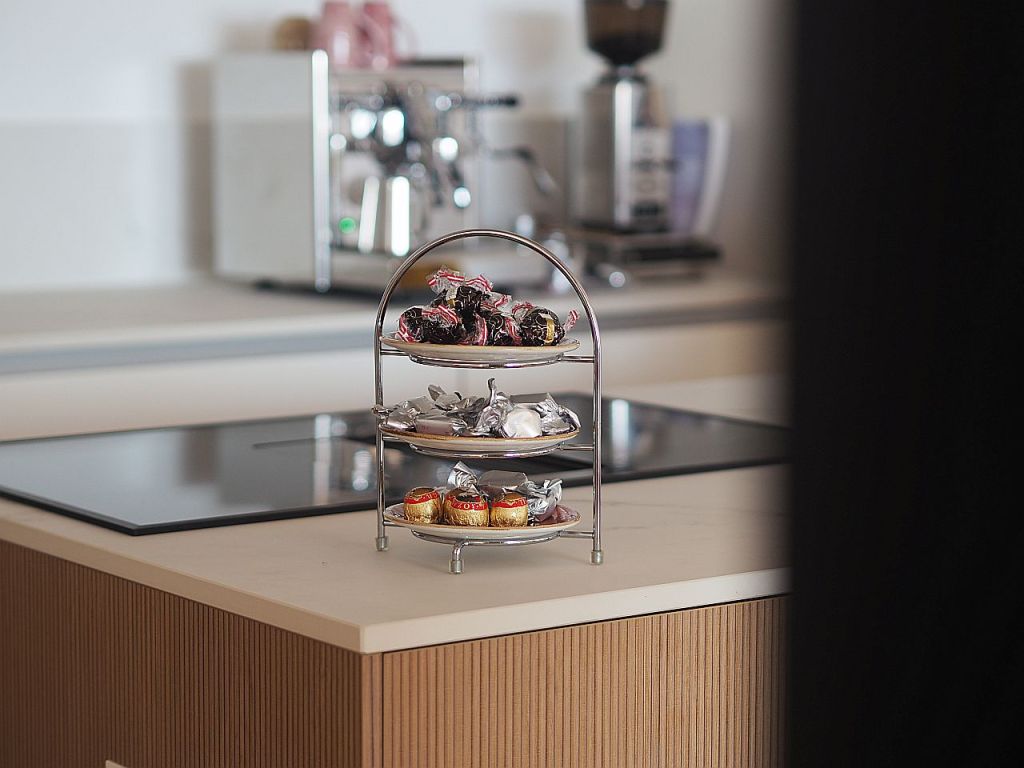 Ein dreistufiger Etagere mit verschiedenen Süßigkeiten in einer modernen Küche.